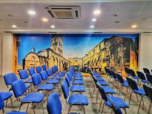 una camera con sedie blu e un grande murale di Hotel Gala Split a Podstrana