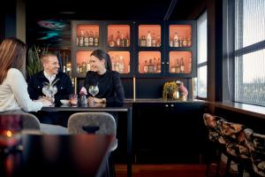 a man and a woman sitting at a bar at Van der Valk Hotel Brussels Airport in Diegem