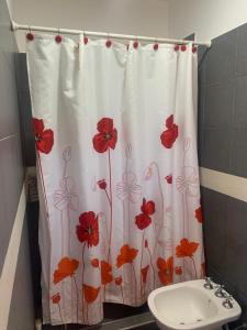 - un rideau de douche avec des fleurs rouges dans la salle de bains dans l'établissement Loft Keler, à Córdoba