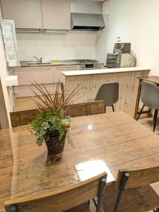 une table en bois avec une plante en pot au-dessus dans l'établissement お宿みとしる, à Mito