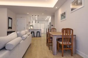 a living room and dining room with a couch and a table at Apartamento NUEVO en el centro de LEON in León