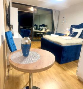 ein Zimmer mit einem Tisch und ein Schlafzimmer mit einem Bett in der Unterkunft Seaside - Apartamenty KOMFORT, widok na morze, Parking in Kołobrzeg