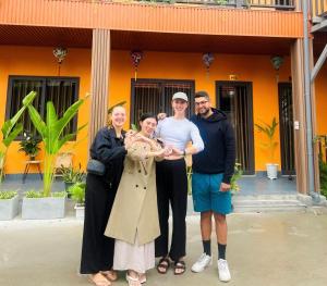 a group of people posing for a picture in front of a house at An Nam Ơi House Homestay in Tam Coc in Vũ Lâm