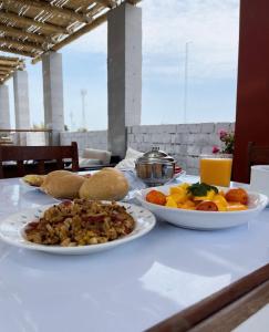 una mesa con dos platos de comida. en Hotel Isla Vela Paracas, en Paracas