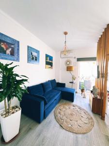 uma sala de estar com um sofá azul e um vaso de plantas em Casa Solua em Reguengos de Monsaraz