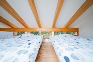 Bett in einem Zimmer mit Holzdecken in der Unterkunft FamA in Nakafurano