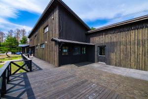 ein großes Holzgebäude mit einer Holzterrasse in der Unterkunft FamA in Nakafurano