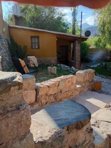 una pared de piedra frente a una casa en La Pirquita, en Tilcara