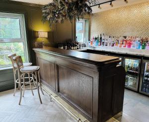 un bar con barra de madera y sillas en una habitación en Tŷ Afon - River House, en Beddgelert