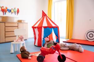 ein Zimmer mit ausgestopften Tieren und einem Spielzeugzelt in der Unterkunft COOEE alpin Hotel Dachstein in Gosau