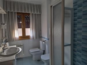 HioにあるApartamentos Cruceiroのバスルーム(洗面台、トイレ付)、窓が備わります。