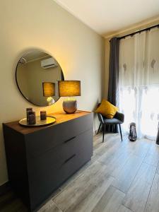 Zimmer mit einer Kommode mit einem Spiegel und einem Stuhl in der Unterkunft Keope Urban Suite in Catania