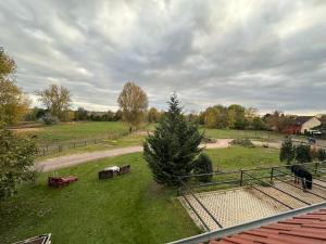 uma vista para um campo com uma árvore e uma cerca em Ruhiges Wohlfühlzimmer auf dem Pferdehof Gut Greppin - mit Kochnische, WLAN & kostenlosem Parken em Greppin