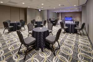 une salle de conférence avec des tables, des chaises et une scène dans l'établissement Hilton Chicago O'Hare Airport, à Rosemont