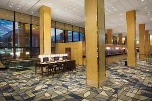 un hall avec une table et des chaises dans un bâtiment dans l'établissement Hilton Chicago O'Hare Airport, à Rosemont