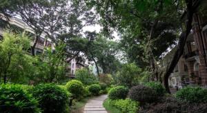 uma passagem através de um jardim com árvores e arbustos em City Comfort Inn Guangzhou Shisanhang Shangxiajiu Pedestrian Street 1st Branch em Guangzhou