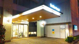 松山Smile Hotel Matsuyama的大楼前有两扇车库门