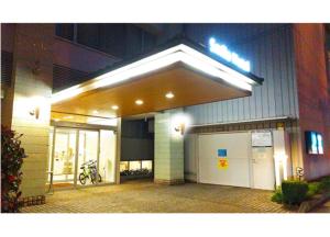 松山Smile Hotel Matsuyama的商店前,晚上有门亮