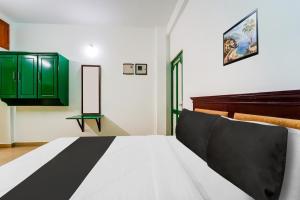 Schlafzimmer mit einem Bett und grünen Schränken in der Unterkunft Super Hotel O Vennala Near Palarivattom in Ernakulam