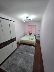 - une chambre avec un lit dans un dortoir doté de parquet dans l'établissement 3х апартаменты на Shymkent Plaza, à Chimkent