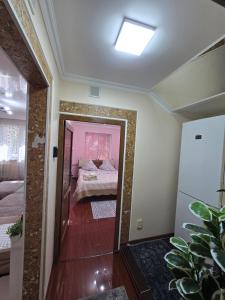 - une chambre avec un lit et un miroir dans l'établissement 3х апартаменты на Shymkent Plaza, à Chimkent