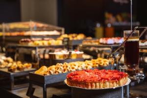 una exposición de pasteles y otros pasteles en una mesa en Hi Hotel - Wellness & Spa, en Trento