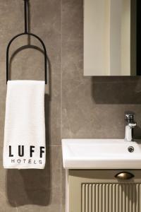 une salle de bains avec une serviette blanche suspendue à un porte-serviettes. dans l'établissement Luff Boutique Hotel - Adult Only, à Kaş