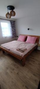 een slaapkamer met een groot bed met roze kussens bij Chata POD HOUBOVÝM VRCHEM 2 in Horní Planá