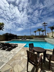 una piscina con mesa y sillas junto a una mesa en Mandai Apartamentos, en Cabo Frío