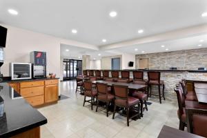 a restaurant with a bar with chairs and a counter at SureStay Plus by Best Western Windsor in Windsor