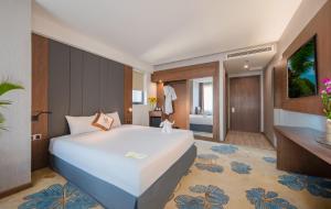 1 dormitorio con 1 cama blanca grande y baño en Vesna Hotel Nha Trang, en Nha Trang