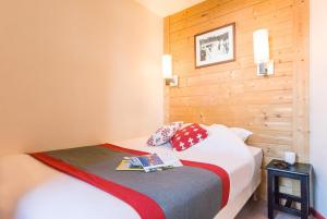 1 dormitorio con 1 cama con pared de madera en Résidence Saskia Falaise - Avoriaz, en Avoriaz