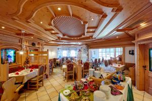 a dining room with tables and chairs and a room filled with food at Hotel Brunnenhof in Bayerisch Eisenstein