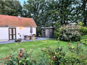 een tuin met een wit huis en een achtertuin bij De Egelburcht in Garderen