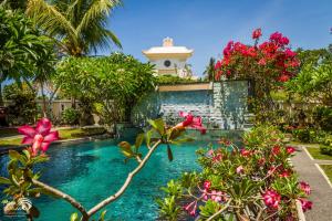 una piscina frente a una casa con flores en Rama Shinta Hotel Candidasa, en Candidasa