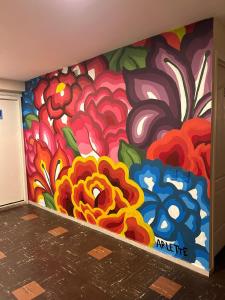 a wall with a painting of flowers on it at Casa Talavera Hostel in Mexico City