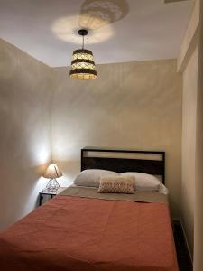 a bedroom with a bed and a lamp and a light at Casa Talavera Hostel in Mexico City