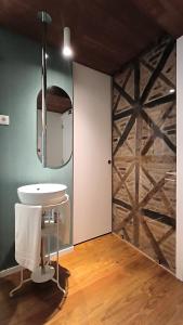 a bathroom with a white sink and a wooden wall at DOMI Suites & Studios in Guimarães