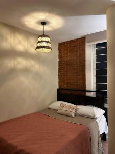 a bedroom with a bed with a brick wall at Casa Talavera Hostel in Mexico City