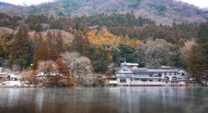 uma casa grande na margem de um lago em Yufuin Onsen Yufuin Nanairo no Kaze em Yufu