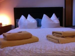 a bed with white pillows and towels on it at Pension Freiraum Guesthouse Berlin in Berlin