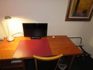 a desk with a computer on top of a wooden table at Pension Freiraum Guesthouse Berlin in Berlin