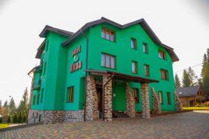 un gran edificio verde con planta Aveth en Kisva Hotel, en Yablunytsya