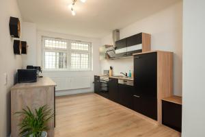 una cocina con armarios negros y una encimera. en Leipzig Mitte - 2 Parkplätze - Koselig Apartments, en Leipzig