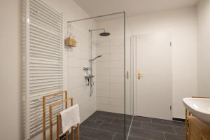 y baño con ducha de cristal y lavabo. en Leipzig Mitte - 2 Parkplätze - Koselig Apartments, en Leipzig