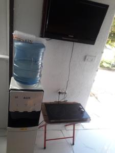 een tv bovenop een doos met een watercontainer bij Rooms Struga in Struga