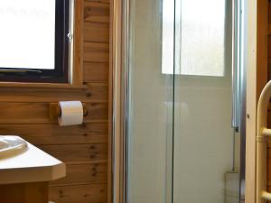 een badkamer met een glazen douche en een wastafel bij Fern Lodge- Burnside Park in Keswick