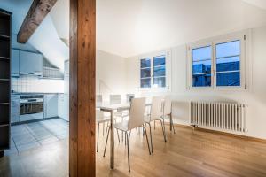 a kitchen and dining room with a table and chairs at Airhome Zug Neugasse Stadtzentrum in Zug