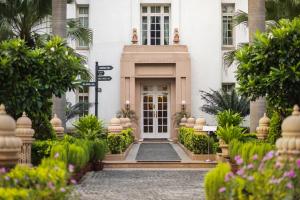 una puerta delantera de un edificio con plantas en The Imperial, New Delhi en Nueva Delhi