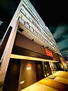 un grand bâtiment avec une façade éclairée la nuit dans l'établissement 嵐 Hotel Arashi 難波南店 Nambaminami, à Osaka